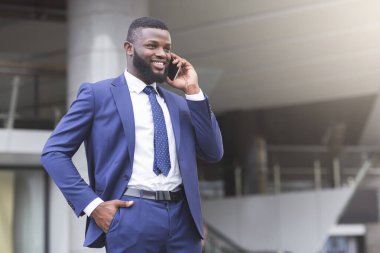 Genç çekici iş adamı telefon edip gülümsüyor.
