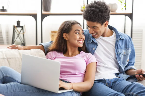 Leende ungdomar som använder laptop tillsammans hemma — Stockfoto