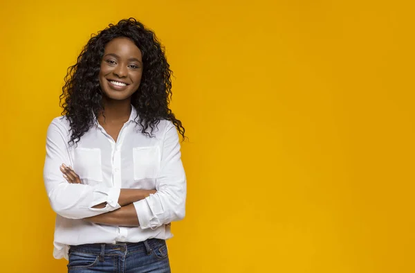 Уверенная улыбающаяся африканская американка со скрещенными руками на груди — стоковое фото