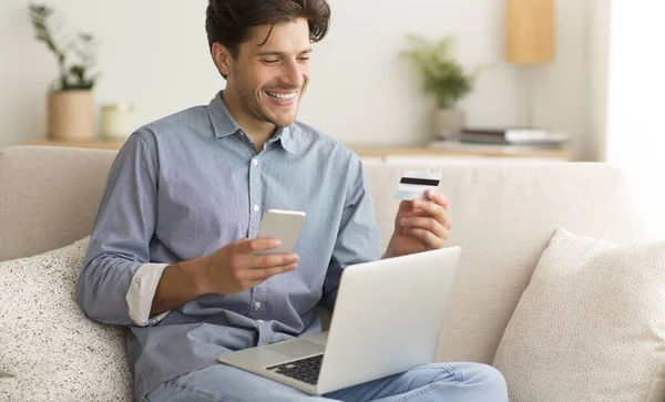 Man Online vásárlás Holding Hitelkártya használata mobiltelefon és laptop — Stock Fotó