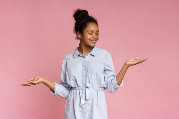 Smiling african american girl demonstrate something on her empty palms — Stock Photo, Image