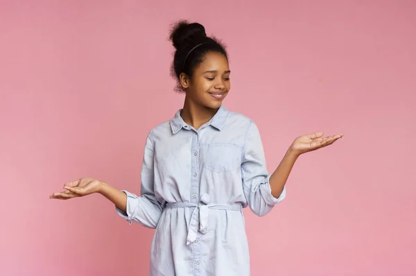 Lächelnde Afrikanerin zeigt etwas auf ihren leeren Handflächen — Stockfoto