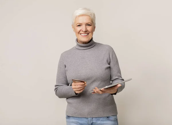 Modern idős nő online vásárlás tabletta és hitelkártya — Stock Fotó