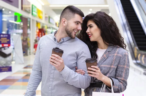 Coppia amorevole con caffè per andare a piedi dal centro commerciale — Foto Stock