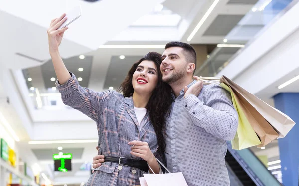 Couple réussi faisant selfie après avoir fait du shopping dans le centre commercial — Photo