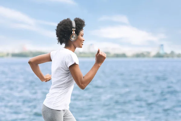 Positivo nero ragazza running fuori lungo fiume embbankment — Foto Stock