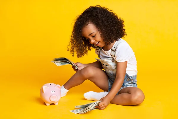 お金の銀行券で遊んでいる小さなアフロの女の子 — ストック写真