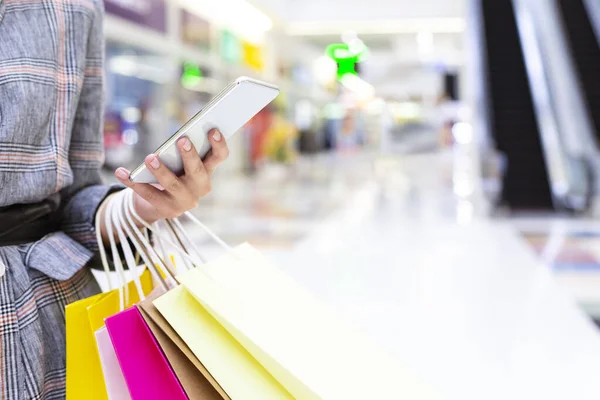 Concepto de compras. Mujer usando smartphone en gran centro comercial —  Fotos de Stock