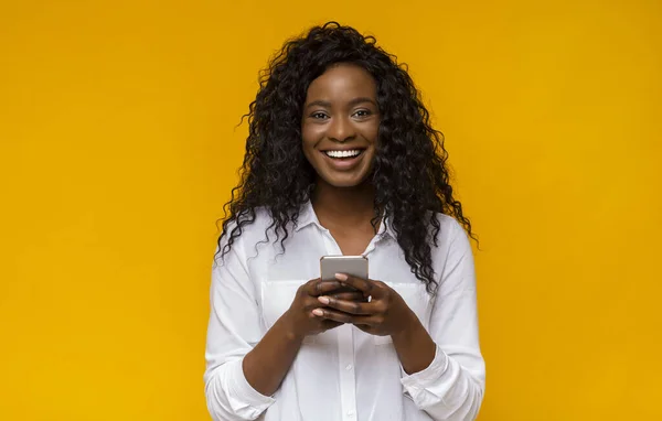 Gelukkig afrikaans amerikaans meisje met behulp van haar smartphone — Stockfoto
