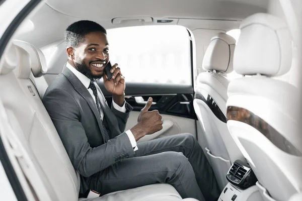 Junger Afro-Geschäftsmann im Luxusauto und zeigt Daumen hoch — Stockfoto