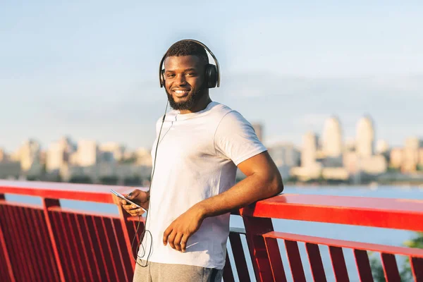 Fešák afro sportovec se usmívá na kameru, zůstává na mostě — Stock fotografie