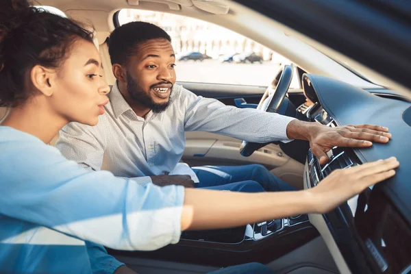 Afro casal no showroom carro tocando traço de novo auto — Fotografia de Stock