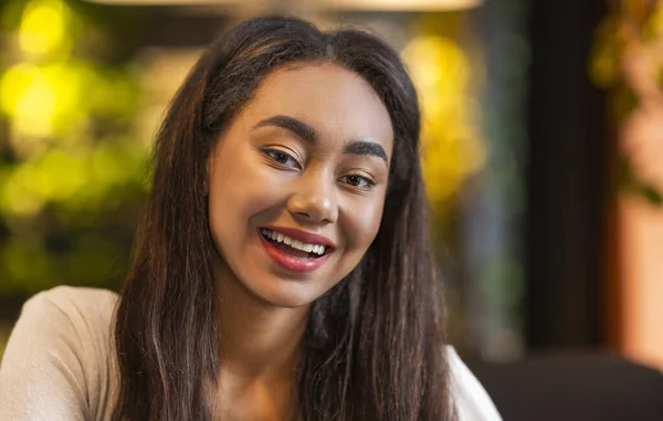 Schönes junges Mädchen lächelt in die Kamera, chillt im Café — Stockfoto