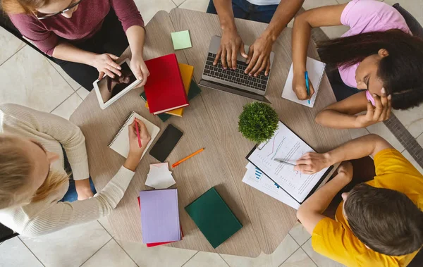 Groep internationale studenten zittend aan tafel, bovenaanzicht — Stockfoto