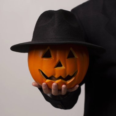 Siyah şapkalı, gülümseyen yüzlü Cadılar Bayramı balkabağı.