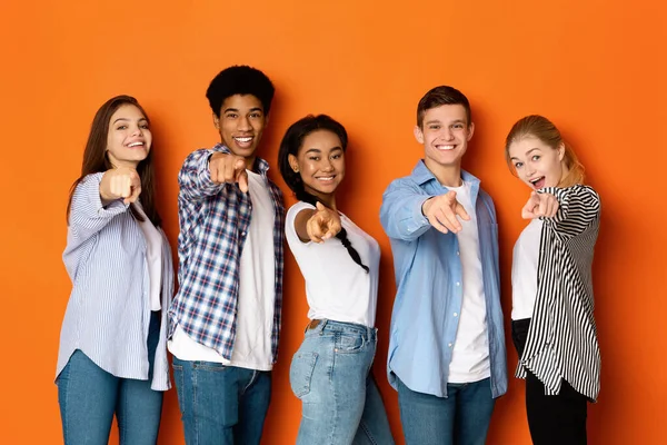 Adolescentes felices señalando con los dedos a la cámara y sonriendo —  Fotos de Stock