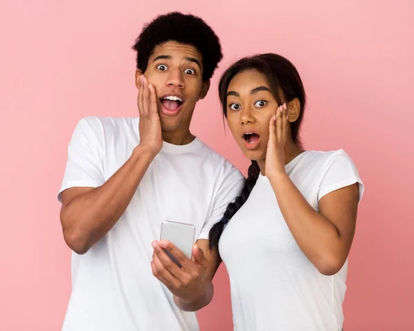 Wow-Verkauf. Geschocktes Paar mit Smartphone blickt in Kamera — Stockfoto