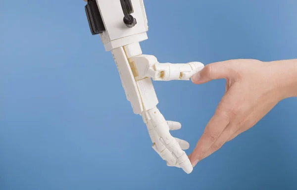 Ανθρώπινα και ρομπότ χέρια κάνοντας χειρονομία καρδιάς σε μπλε φόντο — Φωτογραφία Αρχείου