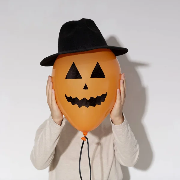 Mujer sosteniendo globo naranja de Halloween con cara de calabaza —  Fotos de Stock