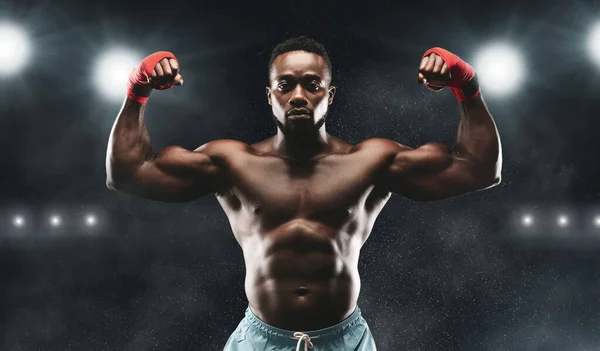 Young kickboxing champion showing his powerful biceps — Stock fotografie