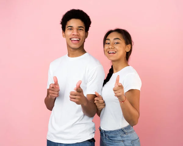 Fröhliches Teenie-Paar zeigt mit dem Finger auf Kamera — Stockfoto