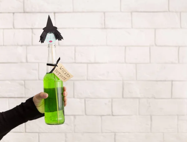 Feliz Halloween bruja bebida verde para saludos en la mano — Foto de Stock