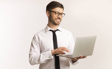 Neşeli İşadamı Dizüstü bilgisayarda çalışıyor Stüdyoda duruyor, Beyaz Arka plan