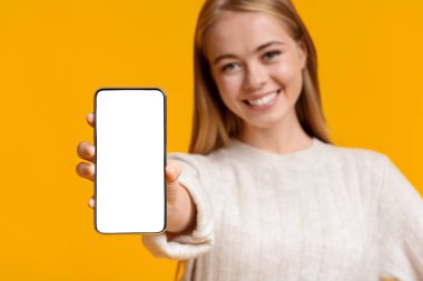 Beyaz perdeyle akıllı telefon sergileyen tatlı bir genç kız.