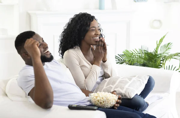 Young black family couple watching comedy movie on tv — Stock Photo, Image