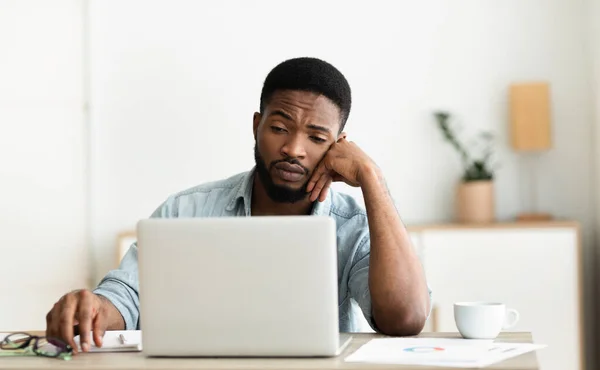 Unatkozó fekete munkás nézi laptop képernyőn, nem tud koncentrálni — Stock Fotó