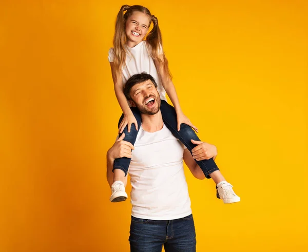 Babası kızını sırtında taşıyor Kameraya gülümsüyor, Stüdyo Çekimi — Stok fotoğraf