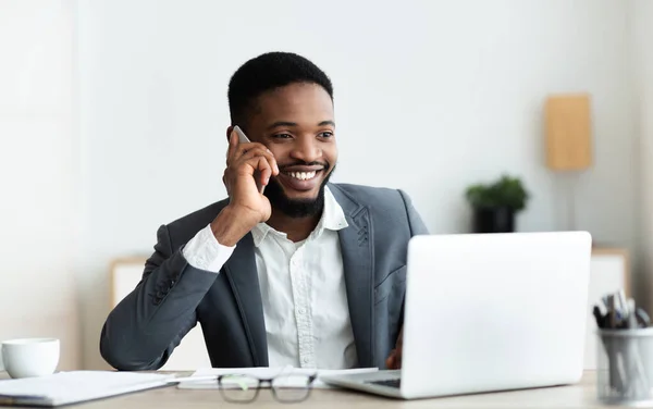 Happy Afro-Amerikaanse werknemer in gesprek op mobiele telefoon op kantoor — Stockfoto