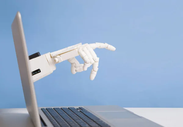 Robot hand reaching out of laptop screen — ストック写真