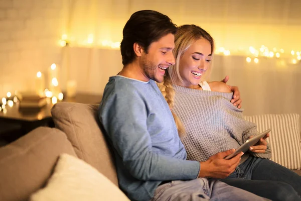 Pareja joven usando tableta pc en acogedora sala de estar —  Fotos de Stock