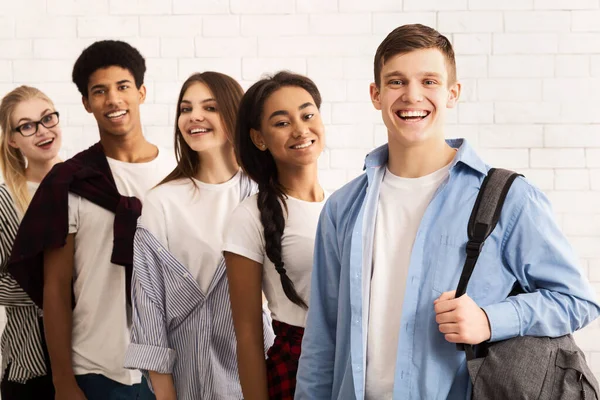 Feliz adolescente amigos sonriendo a la cámara, de pie en fila — Foto de Stock