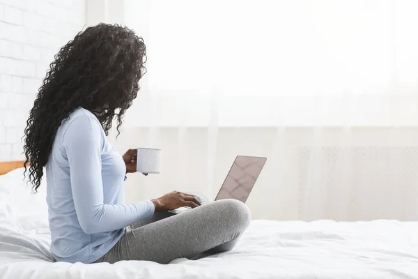 Mujer feliz coqueteando en línea en el ordenador portátil en la cama — Foto de Stock