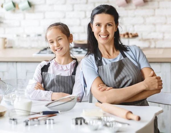 Porträt lächelnder Mutter und Tochter mit Schürzen — Stockfoto