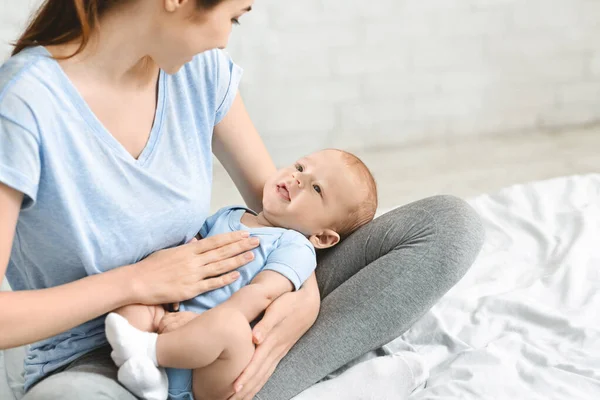 Joven madre arrullando a su adorable bebé en vueltas — Foto de Stock