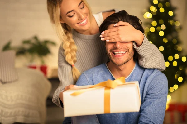 Donna felice marito sorprendente con regalo di Natale — Foto Stock