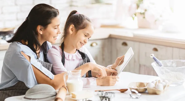 Mädchen und ihre Mutter lesen kulinarischen Blog auf digitalem Tablet — Stockfoto