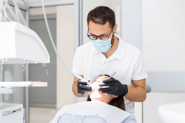 Kadın hastaya dişlerini delen genç doktor