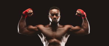 Kaslı yakışıklı kickboksör güçlü pazılarını gösteriyor.