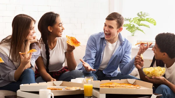 Adolescentes excitados comendo pizza e conversando em casa — Fotografia de Stock