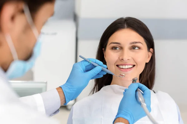 Mulher sorridente olhando para o dentista com confiança — Fotografia de Stock