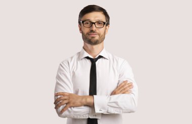 Stüdyoda el ele tutuşan bir işadamı kameraya bakıyor.