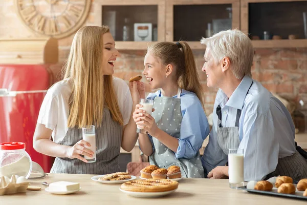 Kedves női család eszik süteményt és tejet iszik a konyhában — Stock Fotó
