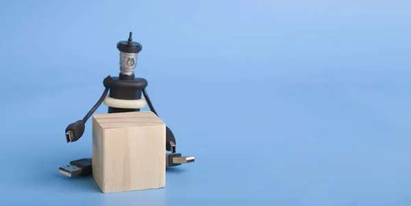 Ręcznie robiony robot kablowy z drewnianą kostką, niebieskie tło — Zdjęcie stockowe