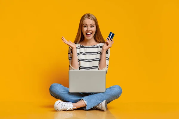 Chica emocionada utilizando el ordenador portátil y tarjeta de crédito para la compra en línea — Foto de Stock