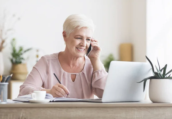 Smiling elderly lady talking to business partners — Stock Photo, Image