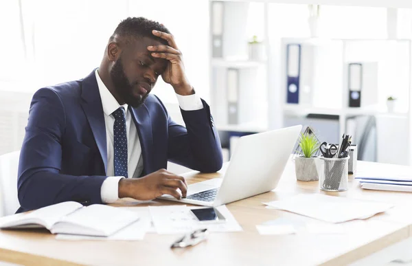 Erschöpfter Jungunternehmer arbeitet mit Laptop im Büro — Stockfoto